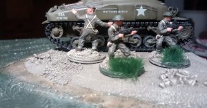 Die MG-Schützen haben nachgezogen. Auf der aus dem Flutgebiet aufragenden Erdscholle versammelt der Offizier seinen Mannen. Der Sherman-Panzer wird das Vorgehen decken.