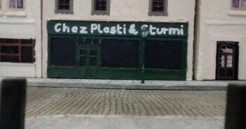 Bienvenu chez Plasti & Sturmi. Die beiden Schöpfer des Dioramas "Saint-Aubin-Sur-Mer" haben sich erlaubt, sich an der Strandpromenade mit einem Bistro zu verewigen. Immer herein mit den Gästen. Bei Plasti & Sturmi ist man willkommen und auf den Pastis muss man nie lange warten.