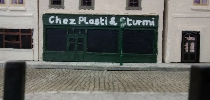 Bienvenu chez Plasti & Sturmi. Die beiden Schöpfer des Dioramas "Saint-Aubin-Sur-Mer" haben sich erlaubt, sich an der Strandpromenade mit einem Bistro zu verewigen. Immer herein mit den Gästen. Bei Plasti & Sturmi ist man willkommen und auf den Pastis muss man nie lange warten.