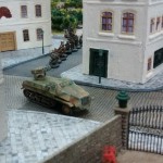 Ein Panzerwerfer 42 biegt in die Straße entlang des Rosengarten ein, gefolgt von einem 10er-Trupp Infanterie. Hier ist das erste Table-Top-Spiel bereits im Gange. Der Spieler der deutschen Seite lässt vorrücken.