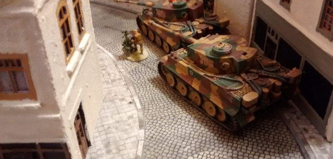 Die beiden Tiger in der Rue Bellengers nehmen sich den verbliebenen Sherman vor. Hauptmann Alsdruf zeichnet das Geschehen auf...