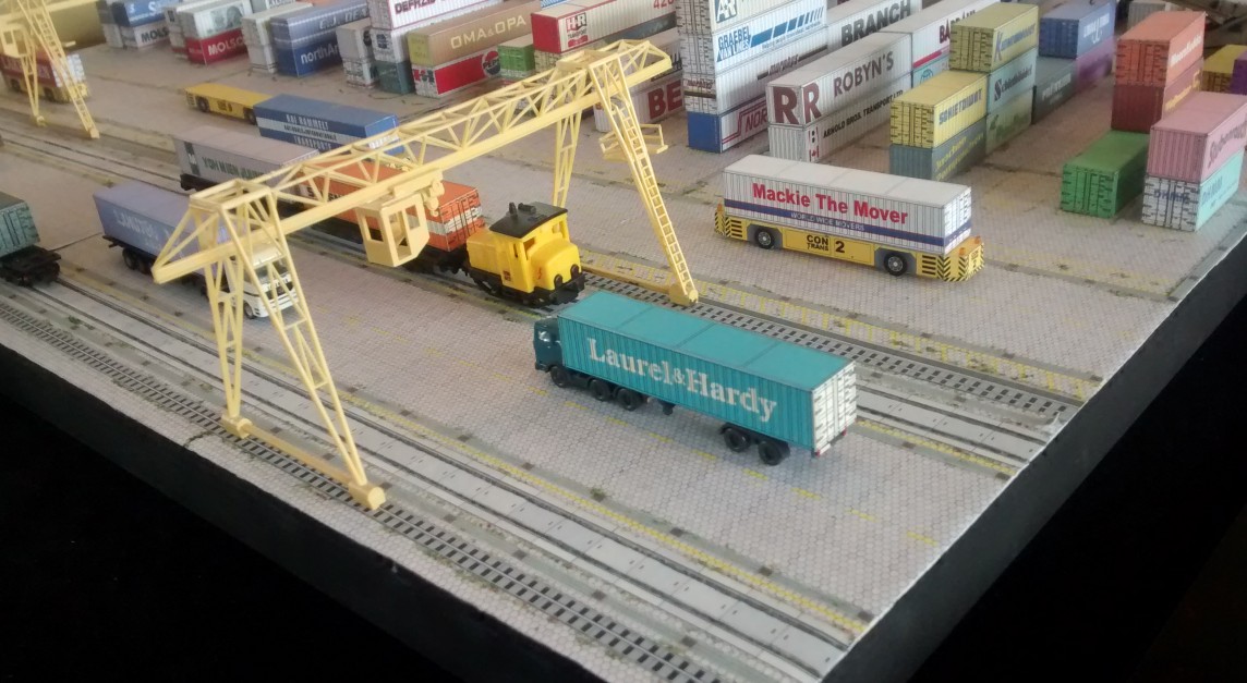 Das Kartonmodell eines Containerterminal ist auch mit einigen Plastik-Modellen ausgestattet.