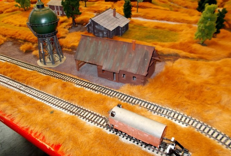 Eine der Behind Omaha Spielplatten. Hier der schmucke Bahnhof mit den Märklin HO-Gleisen. Auch die anderen 1:87-Häuser von der Modellbahn fügen sich stimmungsvoll in das Landschaftsbild ein.