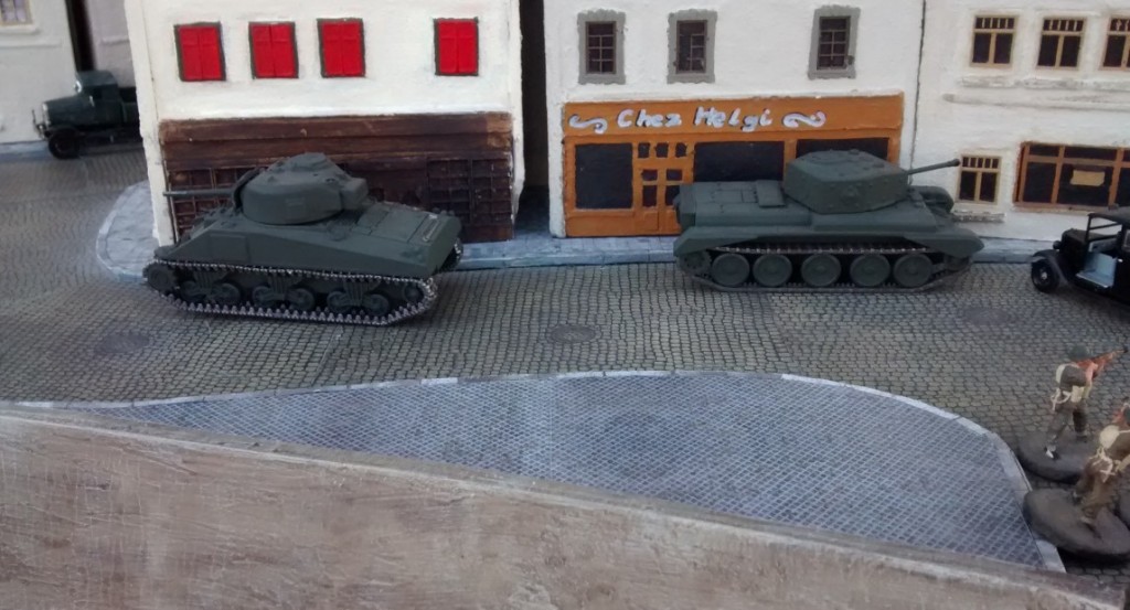 Cromwell und Schörmi ziehen noch nicht vor und verharren in der Deckung der Stadthäuser an der Strandpromenade. Ohne die Deckung durch die begleitende Infanterie will der kanadische Spieler seine beiden wertvollen Tanks nicht den deutschen Nahkämpfern und Panzerschreckschützen des deutschen Spielers aussetzen.