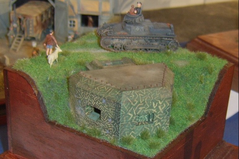 Das Diorama zeigt einen Panzer I auf dem Damm hinter dem Stachelschwein. Ob dies so historisch korrekt ist, kann man bezweifeln. Die Bunker des Typs Sta chelschwein wurden tatsächlich oft in die Böschung von Dämmen hineingebaut. Allerdings waren die Dämme selten breit genug, einen Kampfpanzer I aufzunehmen.
