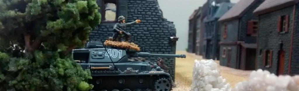 Der Panzerkampfwagen IV wird die Straße des Dorfs überqueren. Er hat Befehl, in die dort in der Nähe befindliche Ferme einzudringen und diese zu besetzen. Na - mal schauen, wer sich durchsetzen wird.