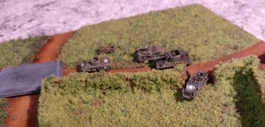Max beginnt seinen ersten Zug mit einem Vormarsch der gesamten Streitmacht entlang der Hauptstraße. Ausnahme der M21 Halftrack 81mm MMC. Der zieht auf die von Bocage eingezäunte Wiese und geht mit seinem 81mm-Mortar in Stellung.