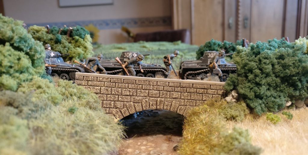 Die drei Panzer I der 3. Kompanie stoßen in Begleitung von Schützen des Schützen-Regiment 113 über eine Brücke über einen Bach bei Givonne westlich von Sedan vor.