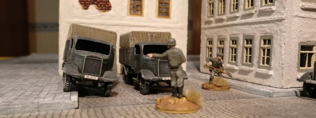 Vor der Bürgermeisterei am Place de la Mairie parkt es sich gut. Zwei der Pegasus 7610 Lkw Mercedes Benz L3000/Opel Blitz der Nachschubkolonne mit einweisendem Offizier.