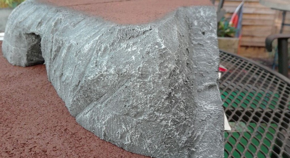 Die graue Oberfläche der Felsen wird mit hellem Grau trockengebürstet. 