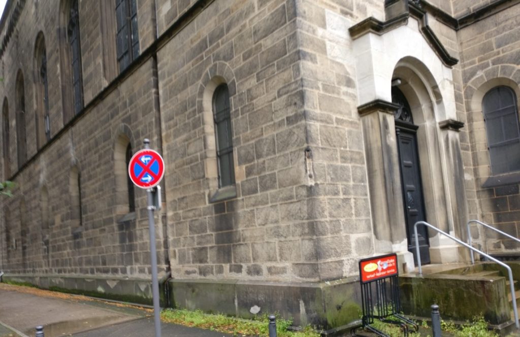 Schöne Kirche in pittoreskem Stadtviertel und das in großen Stückzahlen vorhandene Zeichen 283 StVO, "absolutes Haltverbot".