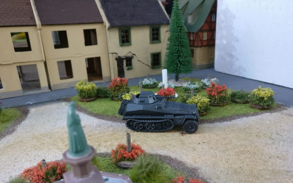 In der "Fritzvorstadt" hält ein Sd.Kfz. 250 in den Parkanlagen zum Beobachten an.