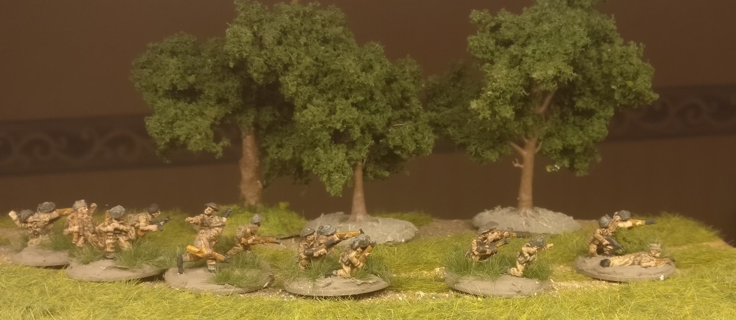 Einge der Rifle Foot Groups des Flames of War British Infantry Platoon erhielten Grasbüschel von MiniNatur und Clump Foliage von Woodland Scenics auf die Base.