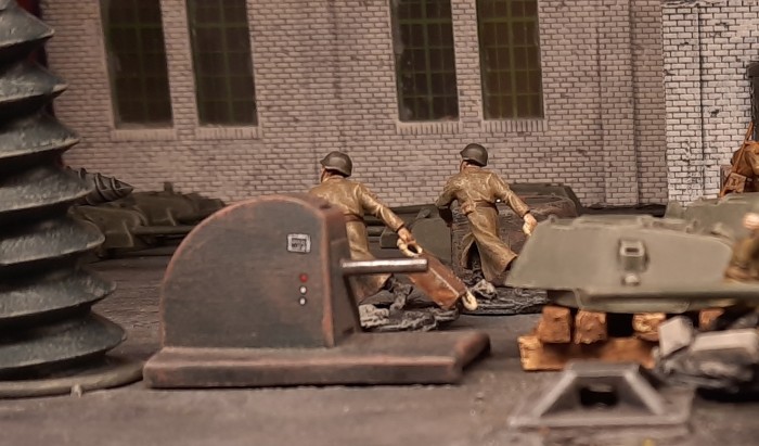 Eilig zerren die Arbeiter (Freiwillige der 44. motorisierten Brigade des 1. Panzerkorps) Kisten mit Werkzeug durch die Halle, um die Montagearbeiter auszustatten.