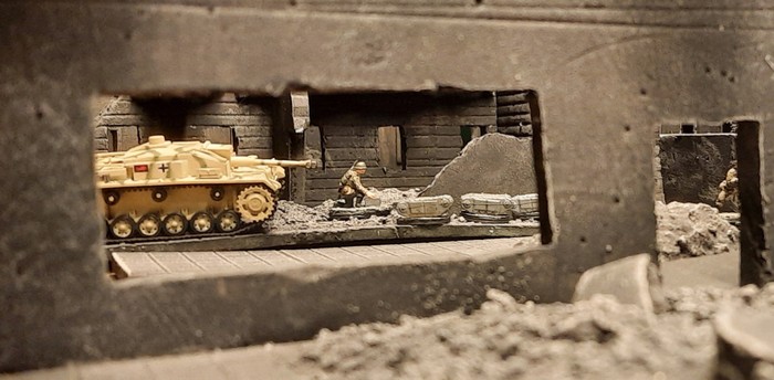 EIn abgesessener Pionier und ein StuG III Ausf. G der Panzer Abteilung 302 (fkl) steuern ein Rudel Sprengpanzer „Goliath V“ Sd.Kfz. 303a („Gerät 671“) entlang der Ulica Dworska 