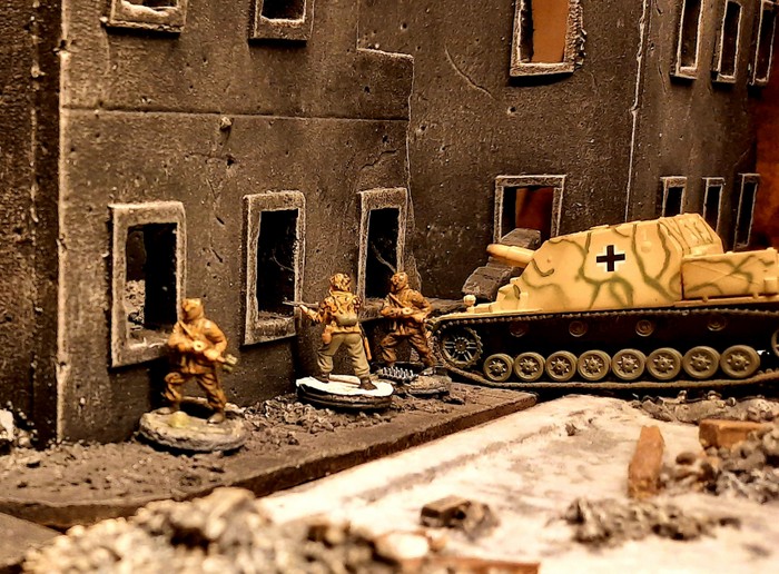 Ein Sturmpanzer IV (Sd.Kfz. 166) der Sturmpanzer-Kompanie 218 z.b.V nimmt in einer Seitenstraße einen Kellerbunker unter Feuer.