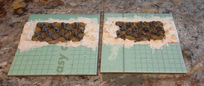 Hier sind XENAs Drachenzähne als Höckerlinie auf die beiden Sarissa-like Terrain Tiles aufgebracht. Links und rechts habe ich die Drachenzähne mit Styrodur-Drachenzähnen ergänzt.